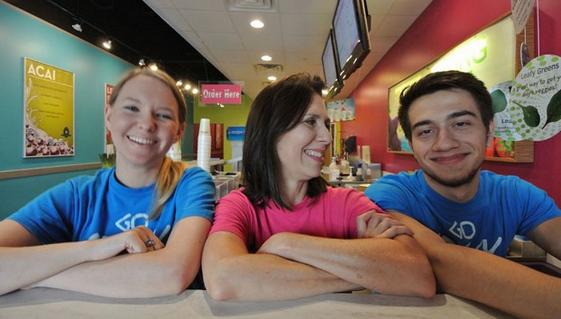 Smiling and diverse planet smoothie employees against a pink and blue background 