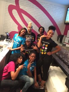 A group of women planet smoothie employees smile behind the counter